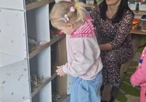 Dzieci przeliczają jajka w kurniku.