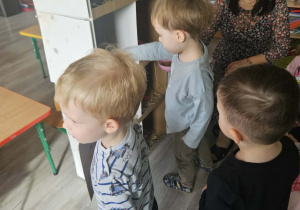 Dzieci przeliczają jajka w kurniku.