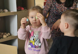 Dzieci przeliczają jajka w kurniku.