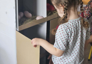 Dzieci przeliczają jajka w kurniku.