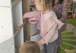 Dzieci przeliczają jajka w kurniku.