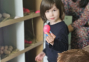 Dzieci przeliczają jajka w kurniku.