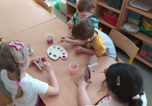 Dzieci tworzą drewniane pisanki.