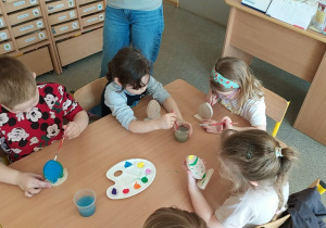 Dzieci tworzą drewniane pisanki.