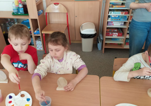 Dzieci tworzą drewniane pisanki.