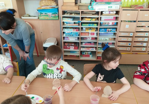 Dzieci tworzą drewniane pisanki.