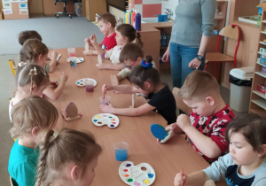 Dzieci tworzą drewniane pisanki.