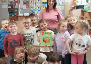 Mama Oli czyta dzieciom książkę.