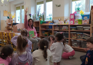 Mama Oli czyta dzieciom książkę.