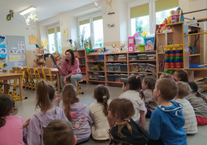 Mama Oli czyta dzieciom książkę.