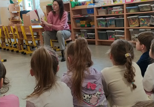 Mama Oli czyta dzieciom książkę.