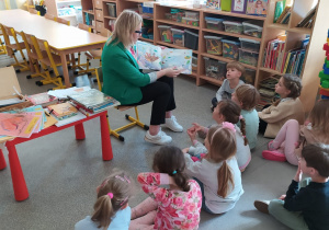 Dzieci świętują dzień książki z panią bibliotekarką.