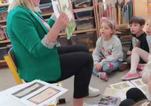 Dzieci świętują dzień książki z panią bibliotekarką.