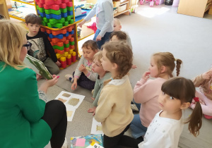 Dzieci świętują dzień książki z panią bibliotekarką.