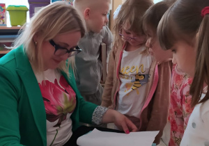 Dzieci świętują dzień książki z panią bibliotekarką.