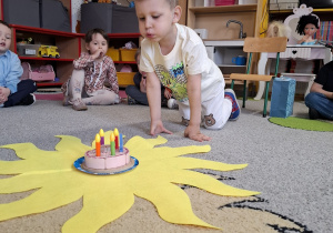 Jubilat zdmuchuje świeczkę na torcie.