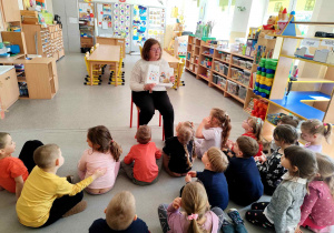 Babcia Milenki czyta dzieciom książkę.