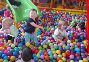 Dzieci bawią się w kolorowej sali zabaw.