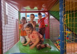 Dzieci bawią się w kolorowej sali zabaw.