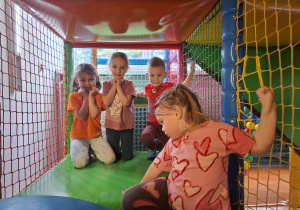 Dzieci bawią się w kolorowej sali zabaw.