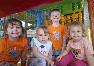 Dzieci bawią się w kolorowej sali zabaw.