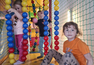 Dzieci bawią się w kolorowej sali zabaw.