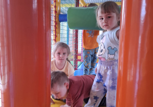 Dzieci bawią się w kolorowej sali zabaw.