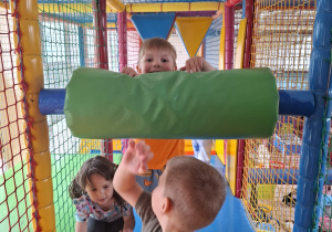Dzieci bawią się w kolorowej sali zabaw.