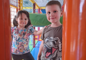 Dzieci bawią się w kolorowej sali zabaw.