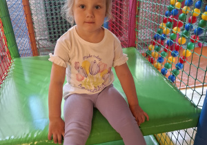 Dzieci bawią się w kolorowej sali zabaw.