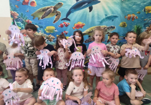 Dzieci z meduzami na tle oceanu.