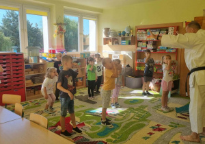 Dzieci ćwiczą z sensejem.