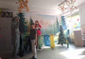 Czerwony Kapturek i Wilk oraz dziecko segregujące śmieci.
