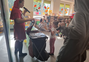 Czerwony Kapturek i Wilk oraz dziecko segregujące śmieci.