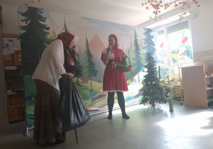Czerwony Kapturek i Wilk oraz dziecko segregujące śmieci.