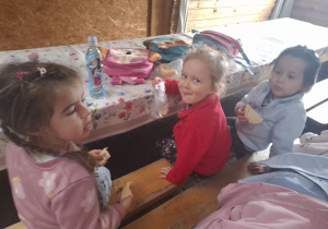 Dzieci przy stolikach podczas poczęstunku.