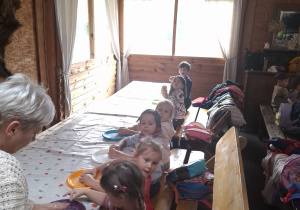 Dzieci przy stolikach podczas robienia chleba.