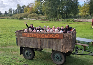 Dzieci jadą wozem po polu.