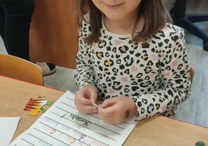 Dziewczynki dekorują list do kolegi.