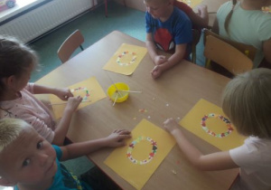 Dzieci wyklejają literę O z kolorowego papieru.