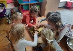 Dzieci z grupy Tygryski przygotowują ciasto ze śliwkami.