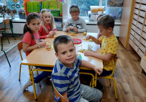 Dzieci przy stoliku robią jeża z ziemniaka i wykałaczek.