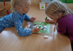 Dzieci przygotowują obrazek z puzzli.