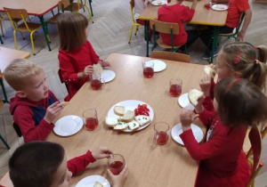 Dzieci jedzą czerwone śniadanie.