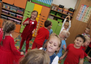 Dzieci bawią się z czerwonym kolorem.