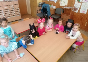 Dzieci siedzą przy stoliku.
