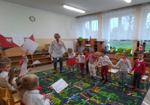 Dzieci wspólnie podziwiają swoje stroje w kolorach Polski.