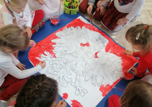 Dzieci z godłem Polski wykonanym na papierze.