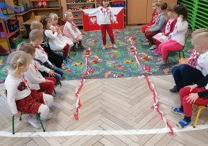 Dzieci ubrane na biało-czerwono biorą udział w pokazie mody patriotycznej.