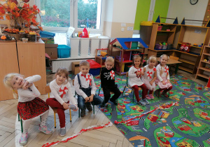 Dzieci stoją ubrani na biało-czerwono.
